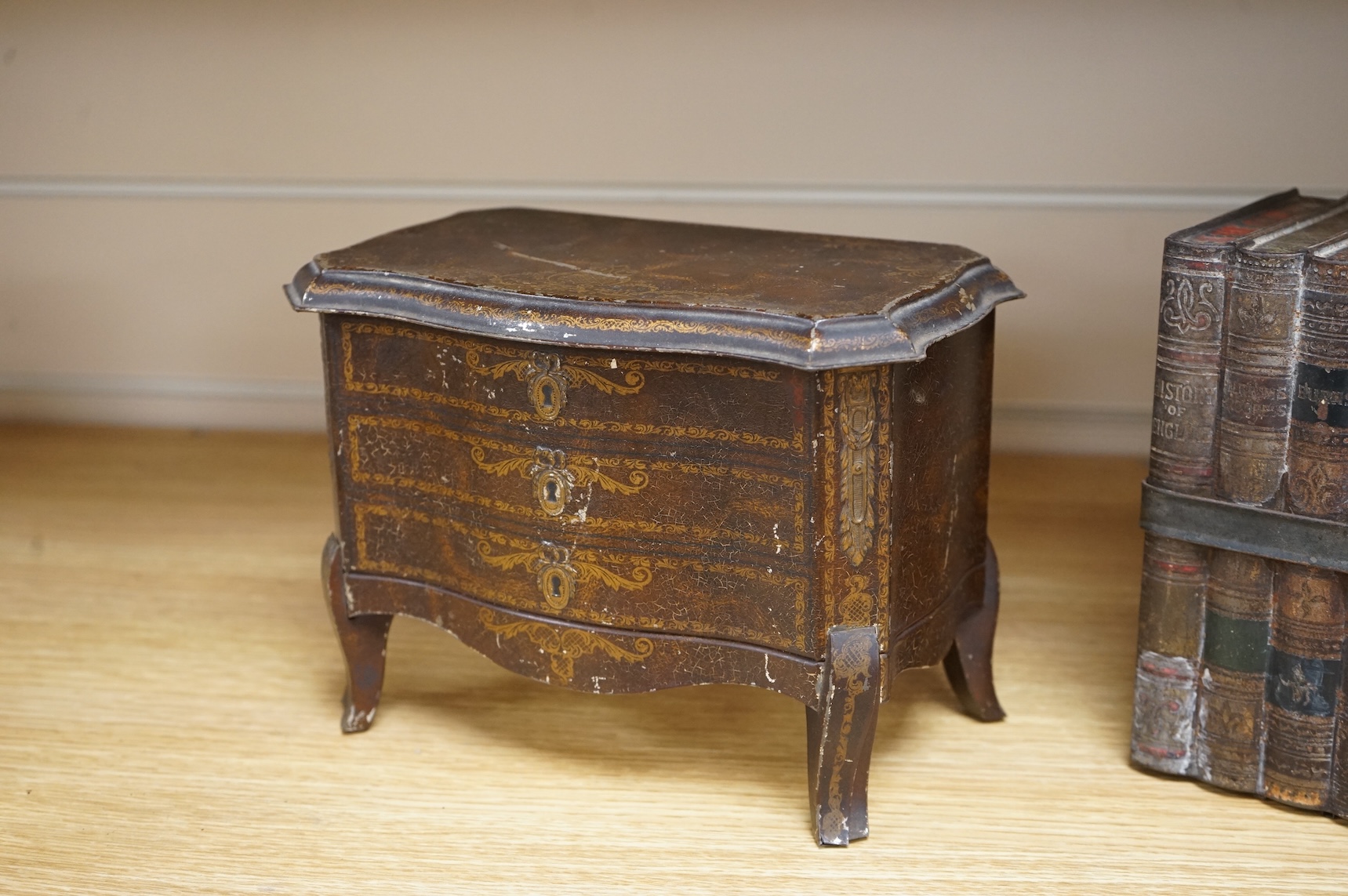 A Huntley and Palmer biscuit tin, modelled as a set of books and and two Mcvitie and Price tins modelled as French chests, tallest 16cm